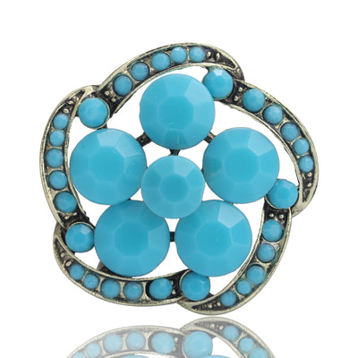 Turquoise openwork flower brooch front on white with reflection