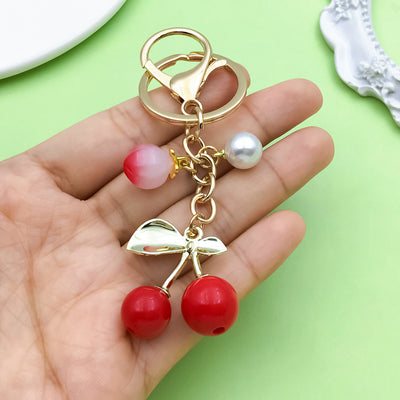 Image 1 showing a hand holding two rings with red and white beads.