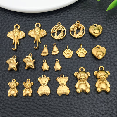Gold-tone bear and elephant charms arranged on a light background