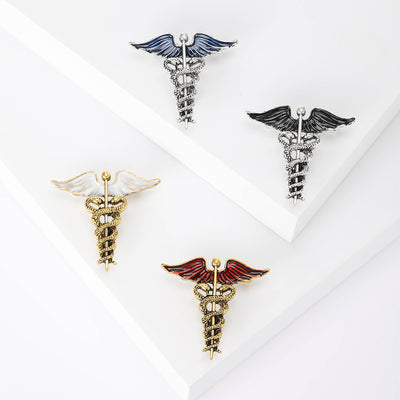 Four caduceus brooches with white red black and blue enamel wings