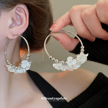Gold Tone Hoop Earrings With White Floral and Pearl Like Accents