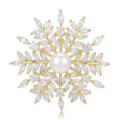 Gold starburst pearl center crystal brooch white background