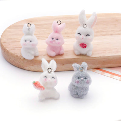 Multicolor rabbit charms arranged on a light background