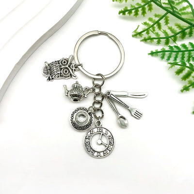 Main display of silver tone teapot cup and cutlery charm keychain