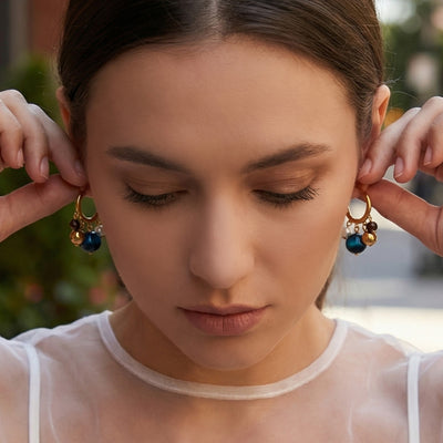 On-ear view of tiger eye and pearl cluster hoop earrings in main image 1.