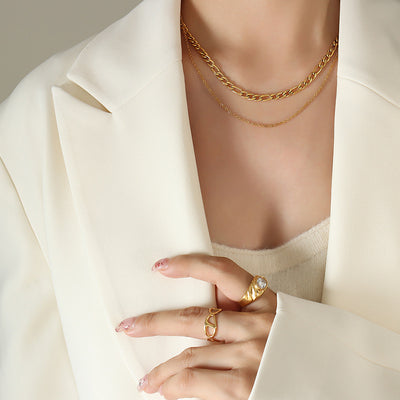 Gold double-layer Figaro and fine chain necklace on cream blazer