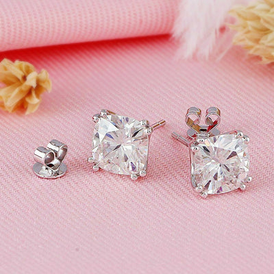 Cushion CZ studs and butterfly backs laid on pink fabric with dried flowers