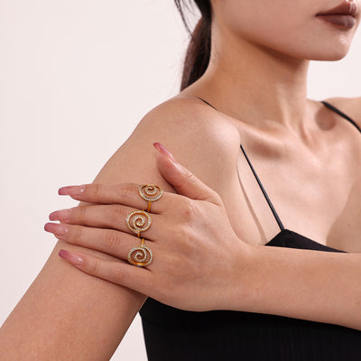 Gold spiral swirl zircon ring worn on index finger beside shoulder