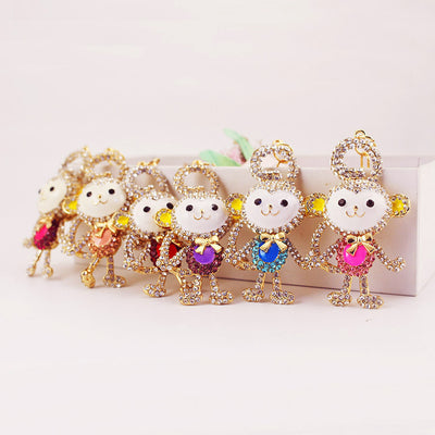 Six gold-tone monkey designs display pink, peach, red, purple, blue, and magenta center accents.