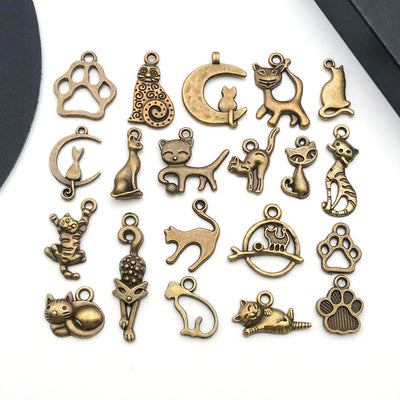 Gold-tone cat and cat paw charms arranged on a light background