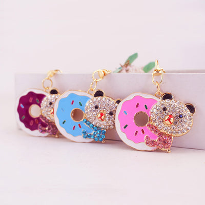 Three bear and donut keychains in purple, blue, and pink displayed together.