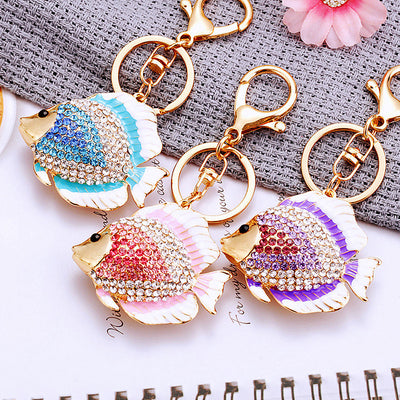 A front product view shows the jeweled tropical fish keychain with its visible ornament and key hardware.