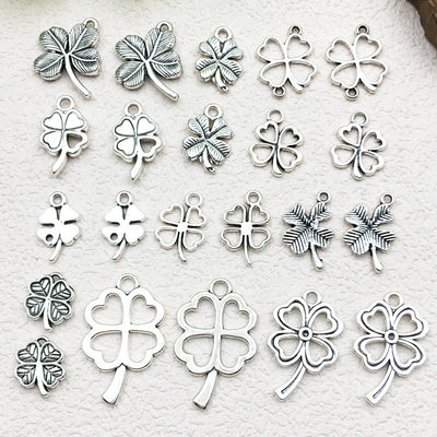 Antique silver four-leaf clover charms arranged on a light background