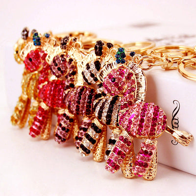Five colored rhinestone zebra keychains arranged together on a white surface.
