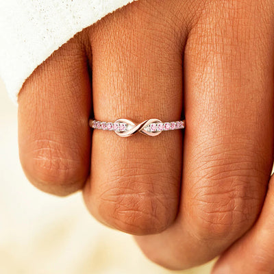 Pink-stone infinity band worn on a finger