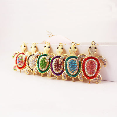 Seven gold-tone sea turtle charms with colored stones arranged in a row.