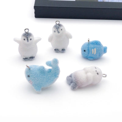 Blue dolphin charms arranged on a light background