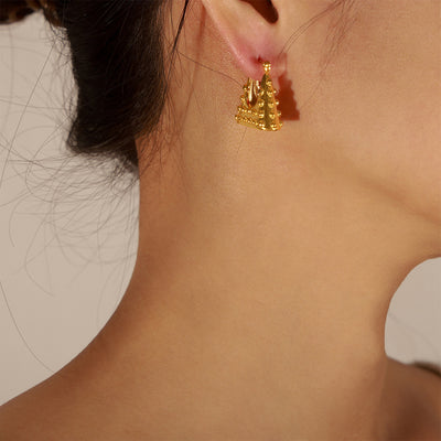 Gold studded triangle bag hoop earring worn on model ear