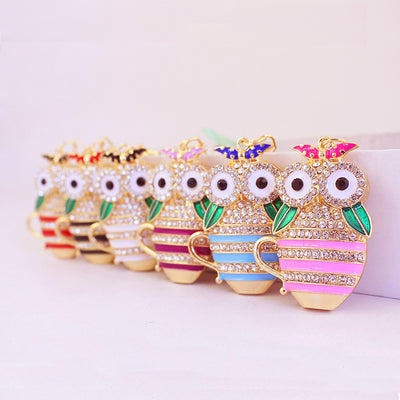 Assorted striped owl teacup charms with clear rhinestones arranged in a row.