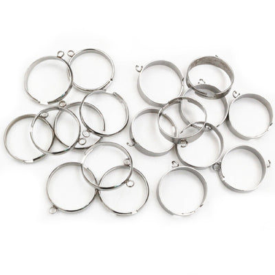 Overview of open stainless steel ring components with a small welded attachment loop on a light background