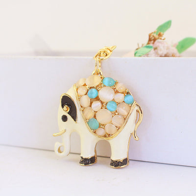 White elephant charm shown from the left side with blue and cream cabochon accents.