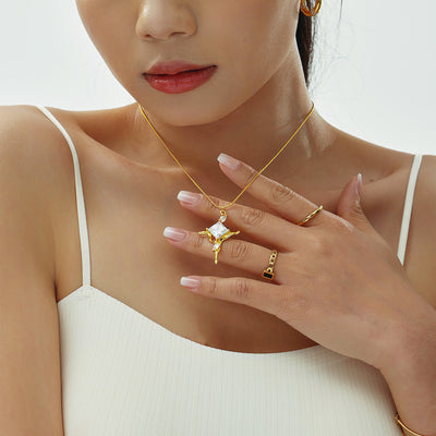 Model wearing gold starburst zircon pendant necklace