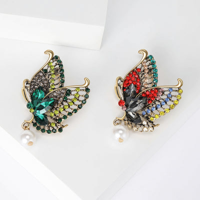 Front view showing the antique gold butterfly brooch with crystal wings and pearl drop