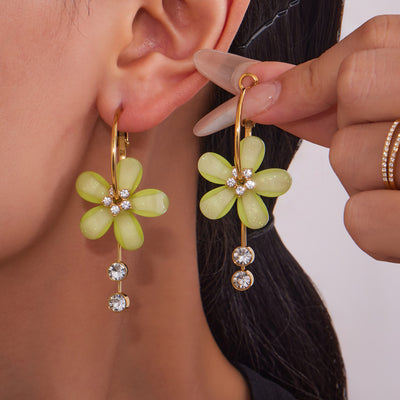 On-ear view of resin flower and crystal tassel hoop earrings in main image 1.
