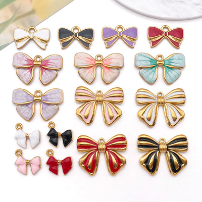 Gold-tone bow and butterfly charms arranged on a light background