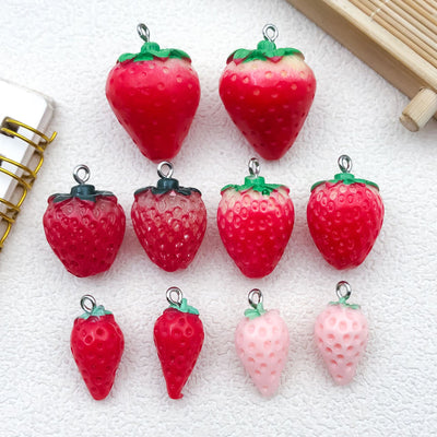 Multicolor strawberry charms arranged on a light background