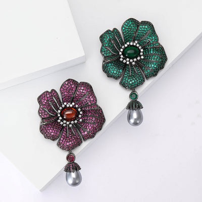 Magenta and green pave crystal flower brooches with pearl drops on white blocks