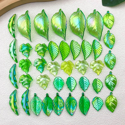 Colorful leaf and strawberry charms arranged on a light background