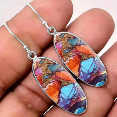 Antique silver multicolor oval drop earrings held in hand
