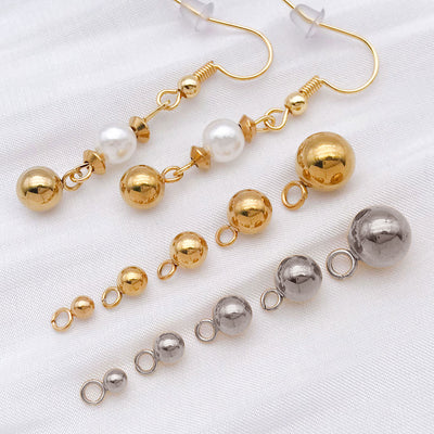 Metallic round bead charms arranged on a light background