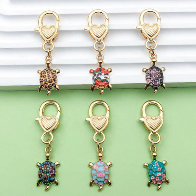 Image 1 showing a bunch of different colored charms on a green surface.