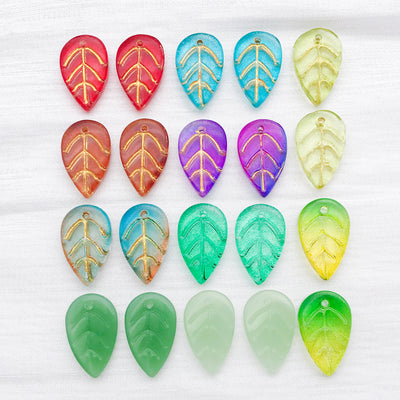 Metallic leaf charms arranged on a light background