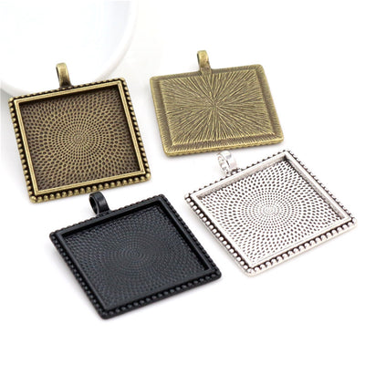 Overview of square pendant trays with radiating geometric textures on the reverse on a light background