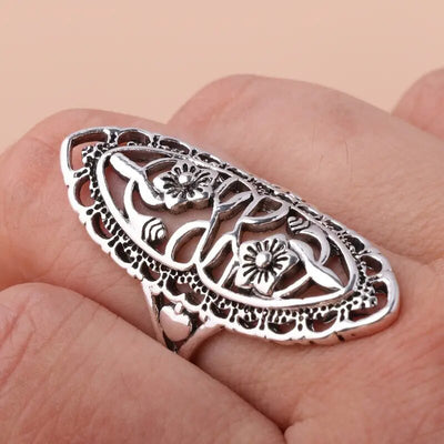 Antique silver filigree floral oval ring on palm close detail