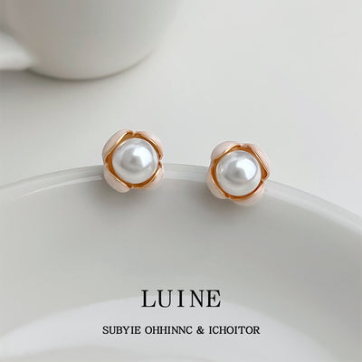 Pearl cream enamel bud studs on white ceramic plate