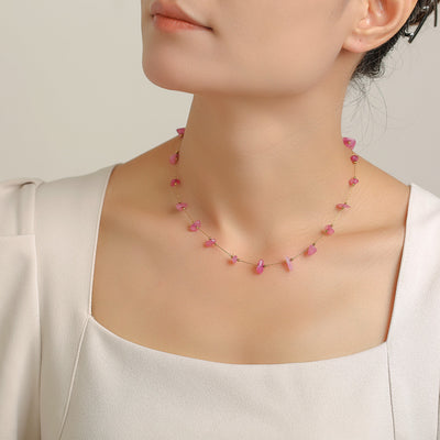 Pink stone chip necklace worn as collarbone chain on light top