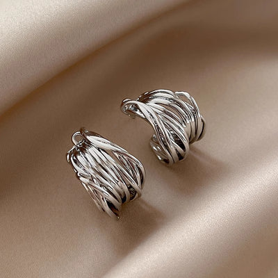 Silver multi-strand twisted C studs on beige satin