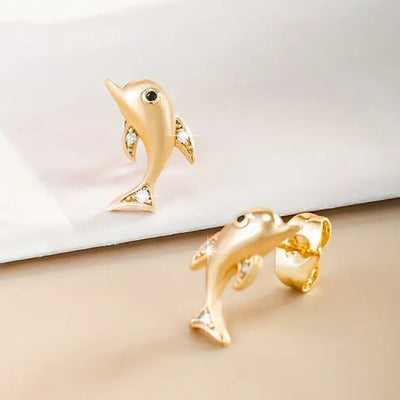 gold tone earrings showing curved dolphin shapes with small clear accents