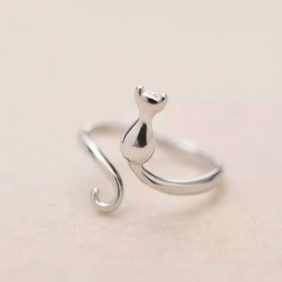 Silver open cat silhouette ring with curled tail beige background