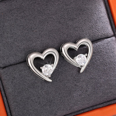 White metal openwork heart clear stone studs on dark gray tray