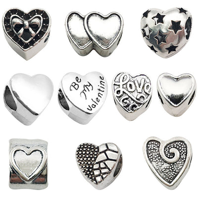 Antique silver heart beads arranged on a light background