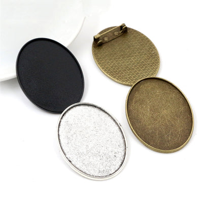 Oval Cabochon Brooch and Pendant Bezel Settings, grouped overview on a plain background