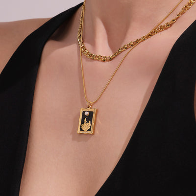 Model wearing gold double layer curb and snake chain enamel pendant necklace