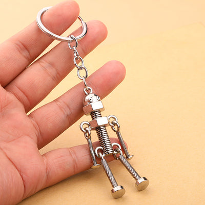 A silver screw robot keychain rests across a person's fingers.