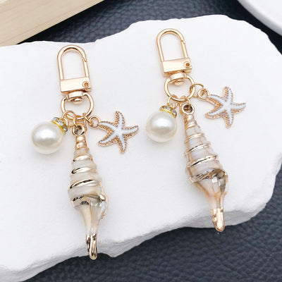 Main display of gold tone conch scallop starfish and pearl-look clasp charms