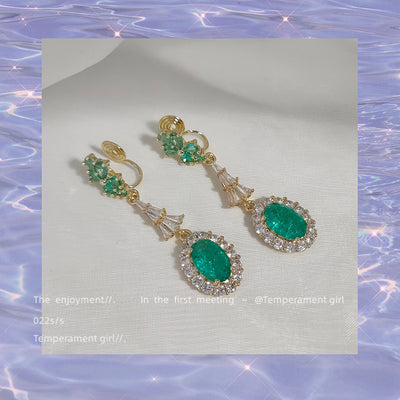 Pair of green crystal long drop ear clips showing spiral coil backs